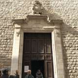 Il portale in legno, decorato con motivi geometrici, � racchiuso in una cornice sovrastata dallo stemma stellato dell'ordine dei carmelitani